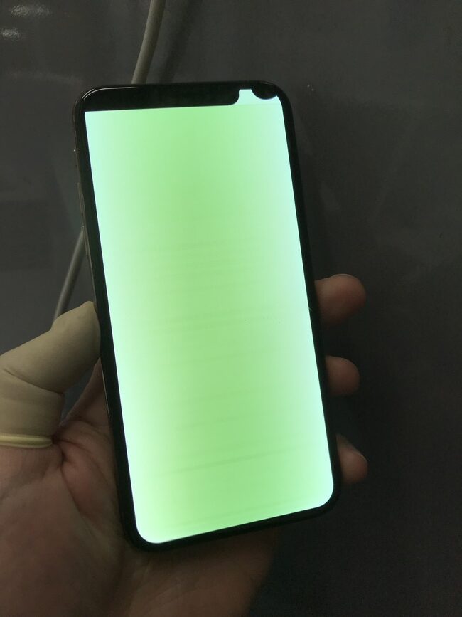 画面全体が緑色になり、明るく光るiPhone